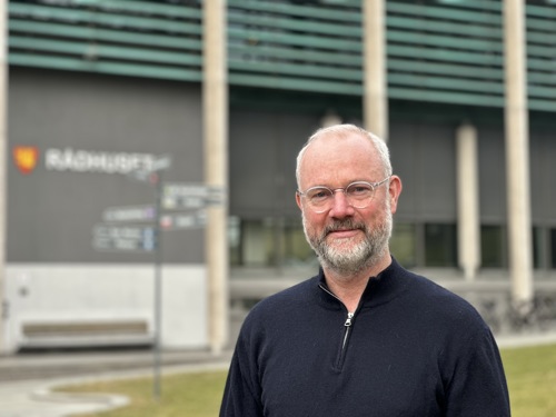 Tormod Hundsnes Førre (51) konstituert byantikvar utenfor rådhuset i Fredrikstad, der byantikvaren jobber.