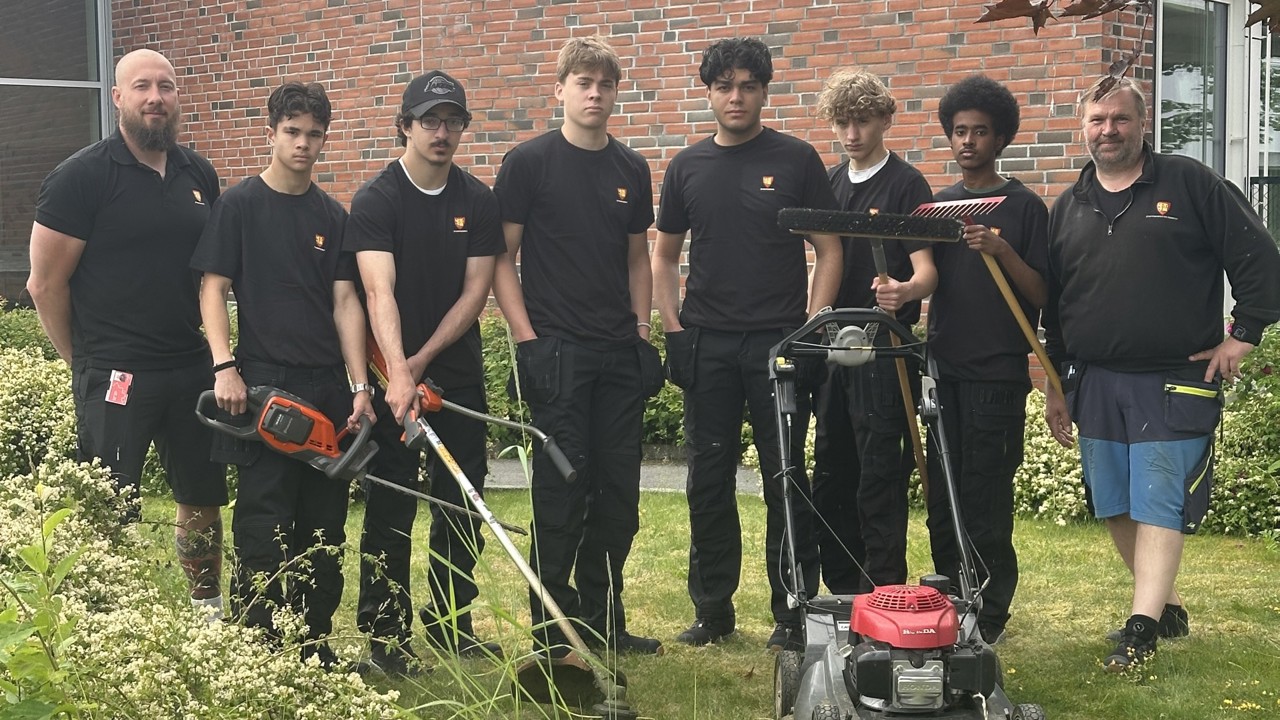Fra venstre teamansvarlig Pål Mangseth med sommervikarene Eric (16), Mohamed (16), Lucas (17), Adam (17) , Abas (17)  og Vilmos (15), som alle skal ha sommerjobb i bygningsdrift i Fredrikstad kommune. Til høyre servicesnekker Morten Ek. Før oppstart fikk de opplæring i sikker bruk av småmaskiner.