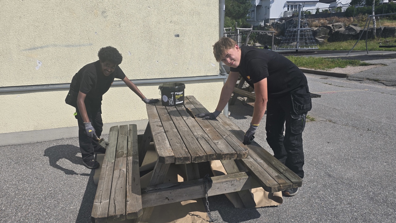 Abas og Lucas oljer benker og bord ved Kjølberg skole