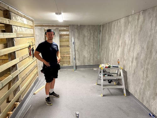 UNDER ARBEID: Tømrer Simen Solbakken fra Mesterbygg monterer baderomsplater.