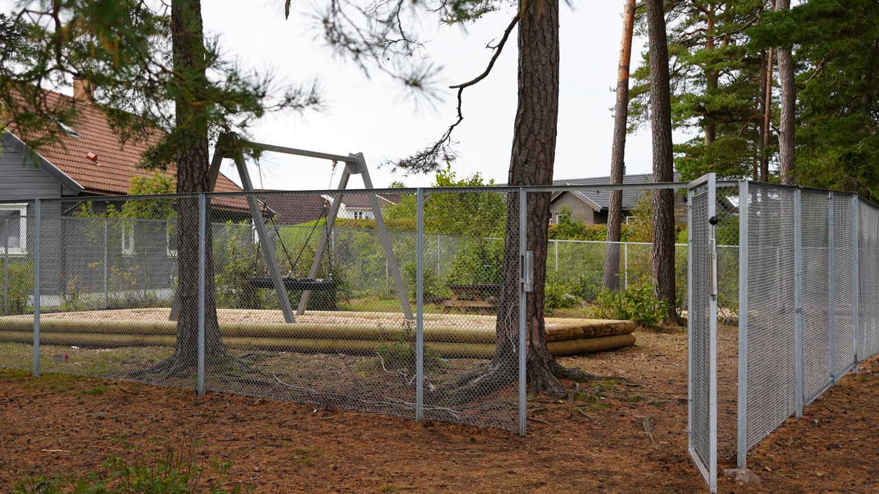 Bildene fra skolegården viser et inngjerdet område med huske, benker og bord. Her er det oversiktlig og godt tilrettelagt for både ro og aktivitet.