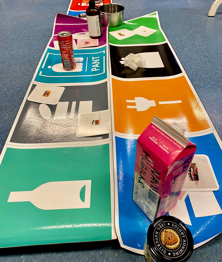 Matte med avfallsymboler og avfall på.