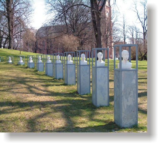 Ut av parken - Skulptur av flere hoder ser ut til å bevege seg ut av parken