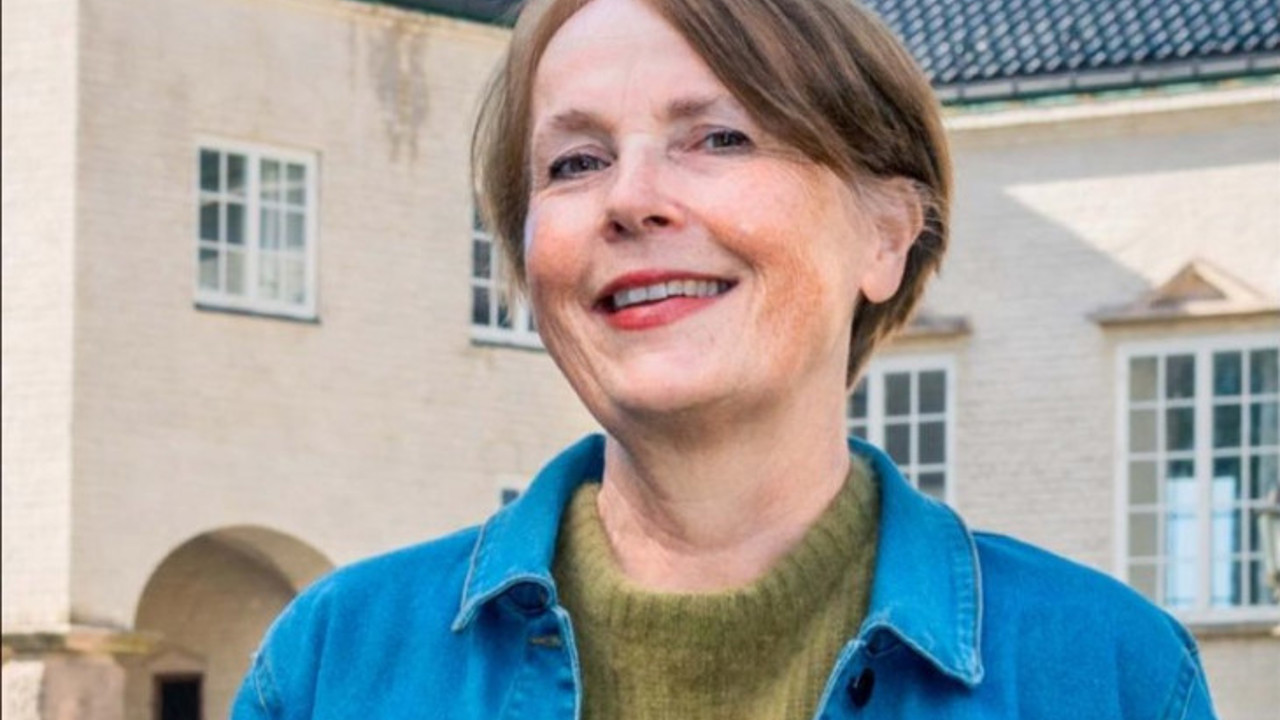 En dame står foran en bygning 