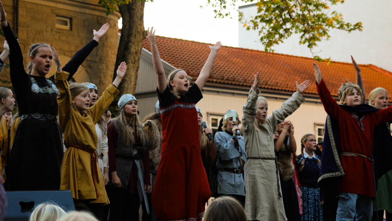 Barn som står på en scene og spiller teater